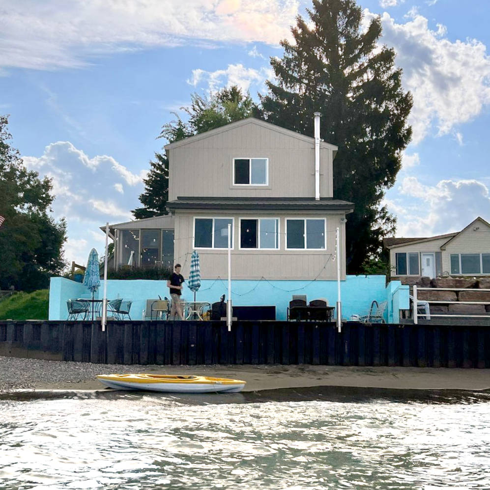 Hunsberger House from the water, showing beach and patio.