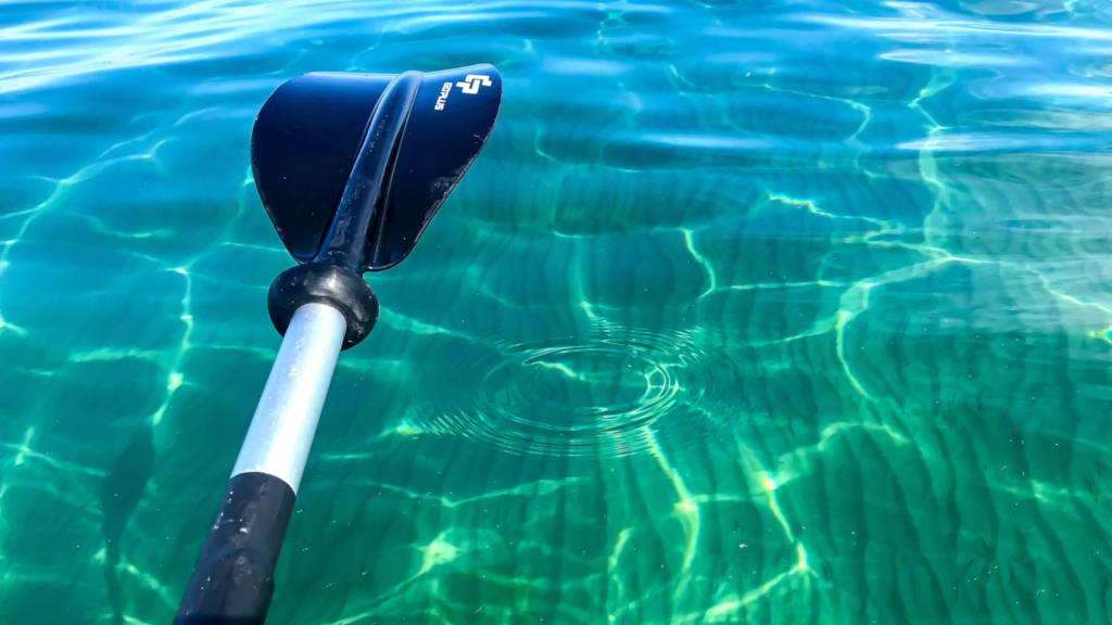 Kayak oar over blue-green water